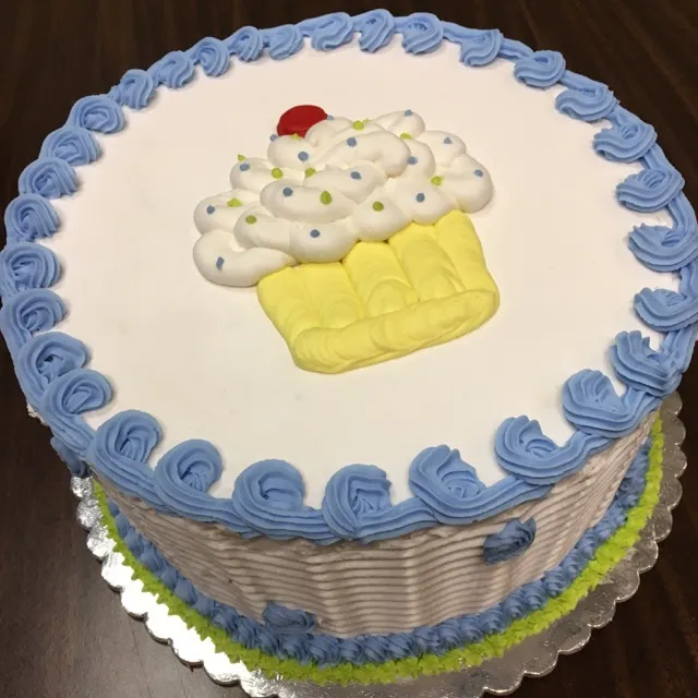 Cake finished in Cake Decorating 1 with a buttercream cupcake and blue rosette border