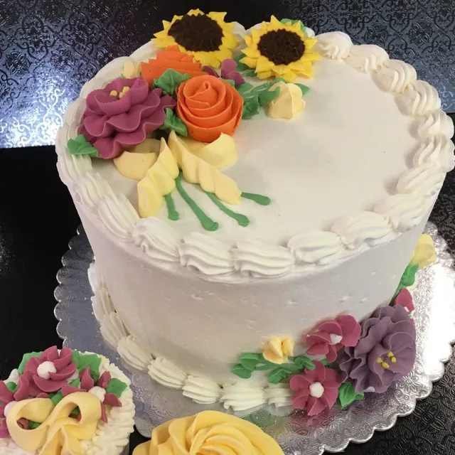 Cake with buttercream sunflowers, roses and sweet peas from Cake Decorating 2